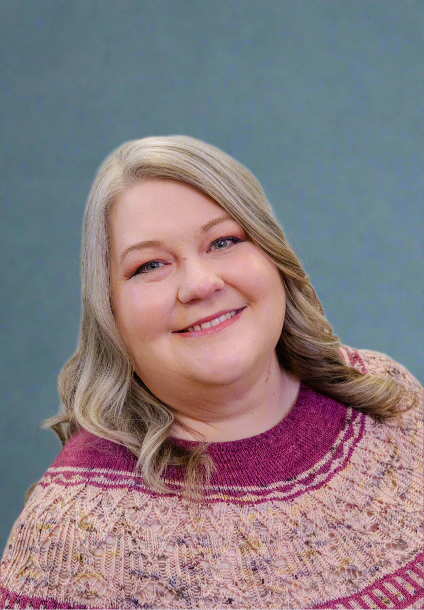 Woman wearing a patterned sweater against a plain background