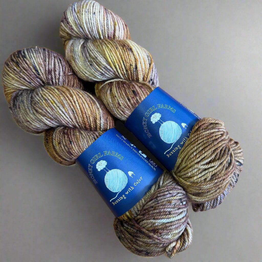 Three skeins of yarn with blue labels on a gray surface